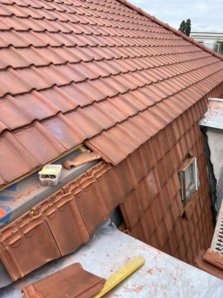 Pose de tuiles par un couvreur sur un chantier à Nyon